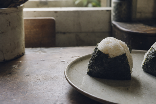 Japanese onigiri rice balls on a ceramic plate in a quiet morning kitchen
